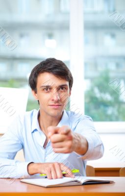 Businessman sitting indoors and writing plan in his diary