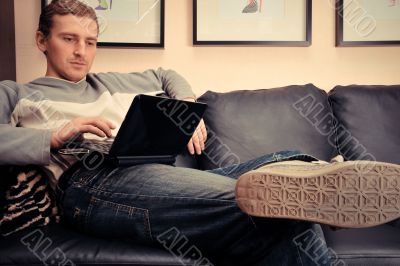 Happy young man  sitting on sofa at home