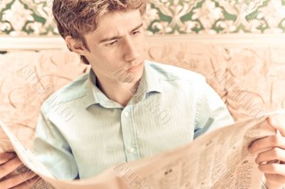 Closeup portrait of young man with newspaper 