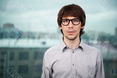 Closeup of a young smiling business man standing against big win