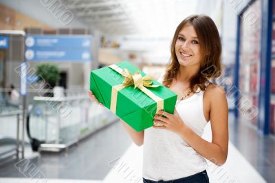 Portrait of young excited pretty woman standing inside shopping 