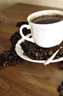 Dramatic photo of world map made of coffee beans. White cup with
