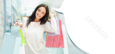 Photo of young joyful woman with shopping bags on the background