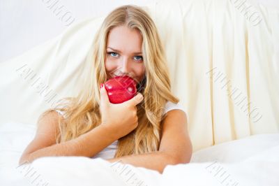 Closeup portrait of young pretty woman lying in her bed at morni