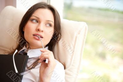 Portrait of a happy young brunette woman holding book