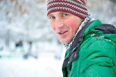 Satisfied smiling businessman standing in the green outdoors