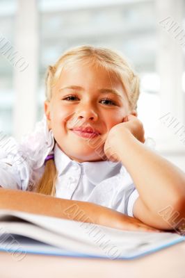 Portrait of a young girl in school at the desk.