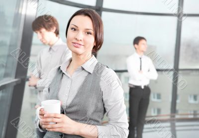 Portrait of a cute business woman with colleagues at the backgro