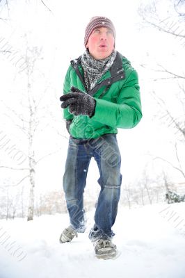 Closeup portrait of young man running in winter park