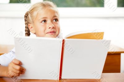 Image of smart child reading interesting book in classroom. Hori