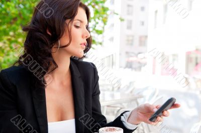 Portrait of young business woman sitting relaxed at outdoor cafe