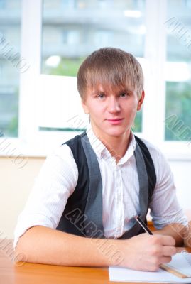 Portrait of young male university student studying in classroom