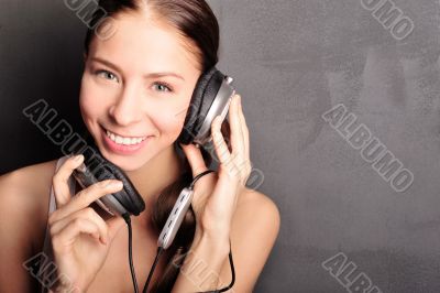 Club style woman with headphones listening to music looking at c