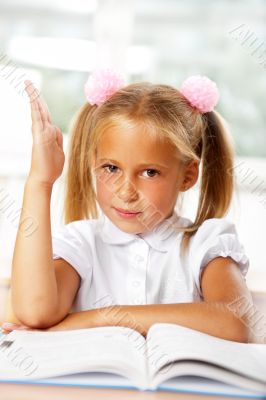 Portrait of a young girl in school at the desk.