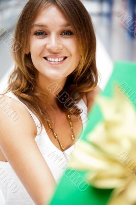 Portrait of young excited pretty woman standing inside shopping 