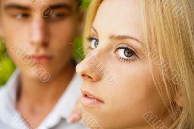 Portrait of beautiful young couple standing against green tree i