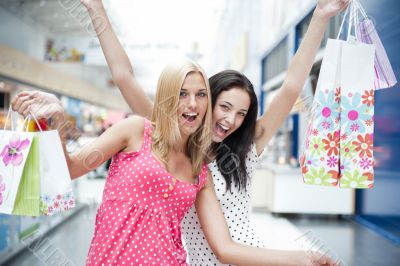 Closeup of two attractive happy girls out shopping