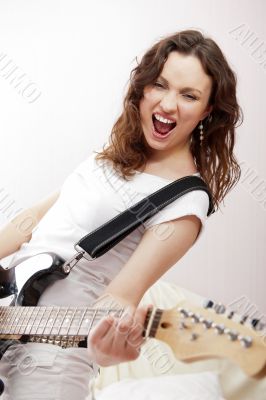 Portrait of beautiful young and attractive womanplaying her guit