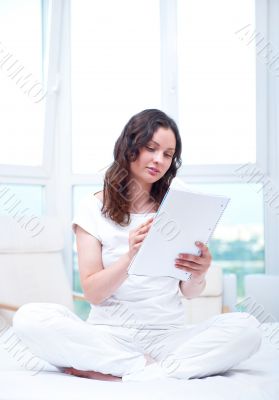 Young woman with a notebook studying at home