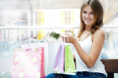 Happy shopping woman with bags and smiling. She is shopping insi