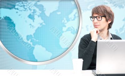 Portrait of happy young business man using her laptop. World map