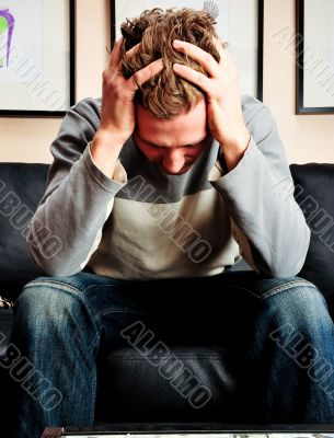 Closeup portrait of young man sitting on sofa 