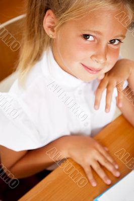 Image of smart child reading interesting book in classroom