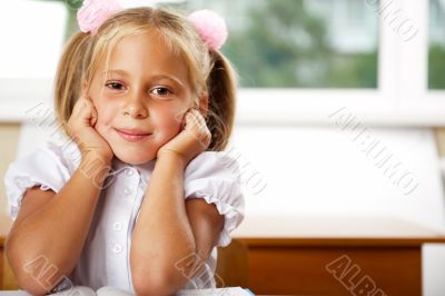Image of smart child reading interesting book in classroom