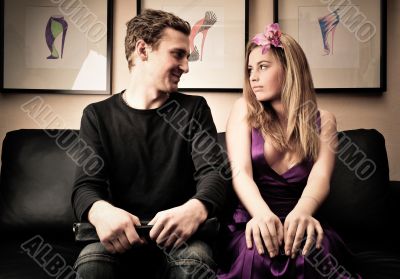 Smiling fashionable rich attractive couple sitting on sofa at ho Smiling fashionable rich attractive couple sitting on sofa at ho