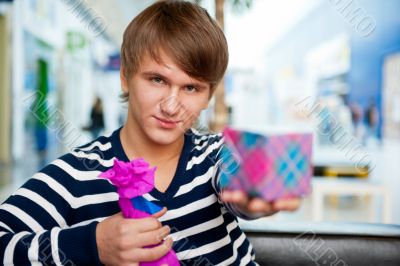 Portrait of young man inside shopping mall standing relaxed and 