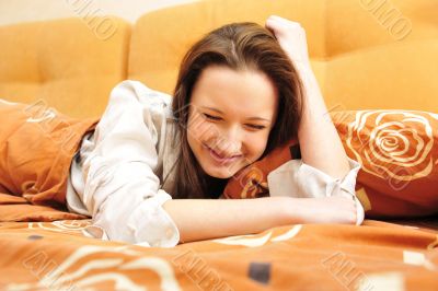 Closeup portrait of young pretty girl laying on her bed