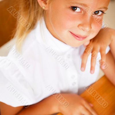 Image of smart child reading interesting book in classroom