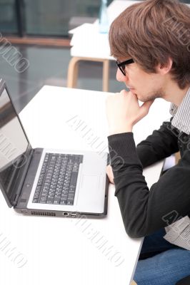 Friendly executive sitting in front of laptop