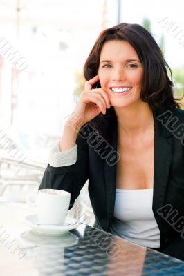 Closeup portrait of cute young business woman smiling while drin
