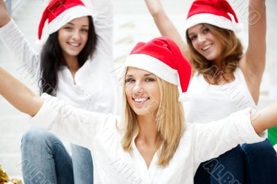 Group of three happy pretty girls are celebrating christmas and 