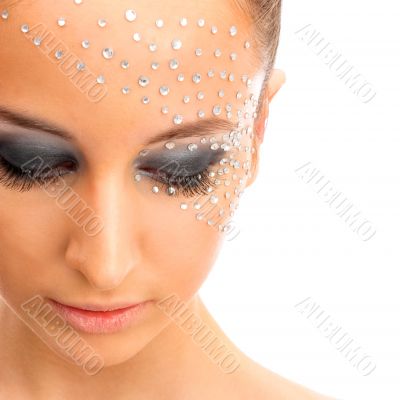 Portrait of young beautiful woman with crystals on face - isolat