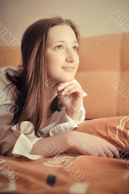 Closeup portrait of young pretty girl laying on her bed