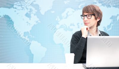 Portrait of happy young business man using her laptop. World map