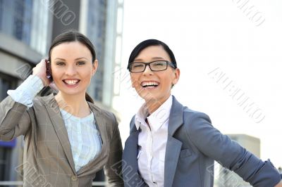 Portrait of two businesswomen outside.