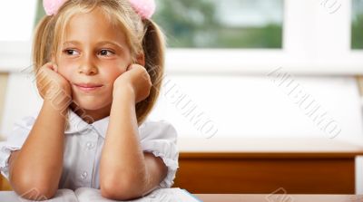 Image of smart child reading interesting book in classroom