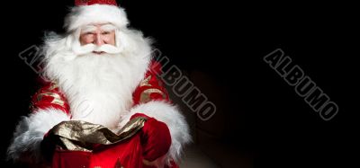 Santa sitting at the Christmas room and looking into the sack