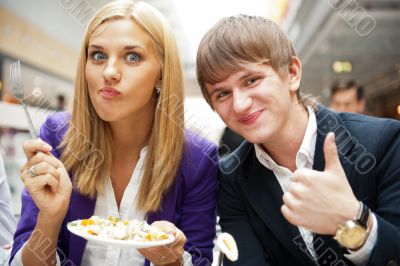 Closeup portrait of an attractive young couple eating fruit sala