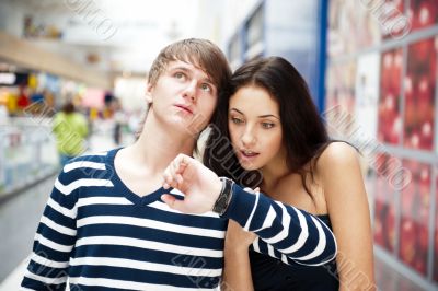 Portrait of young couple standing together at airport hall and l
