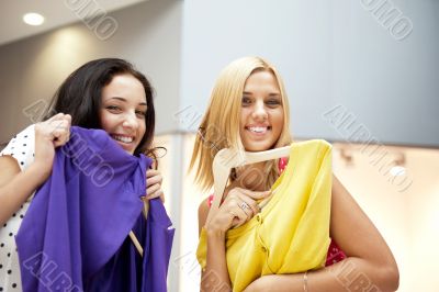 Group of two beautiful shopping women trying on clothes at shopp