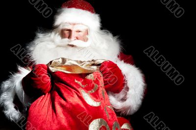 Santa sitting at the Christmas room and looking into the sack