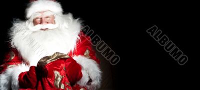 Santa sitting at the Christmas room and looking into the sack