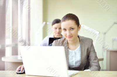 Portrait of two women working at their desks