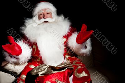 Santa sitting with a sack indoor at dark night room
