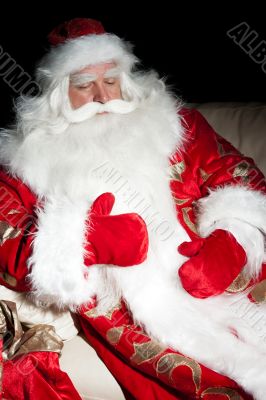 Santa sitting with a sack indoor at dark night room