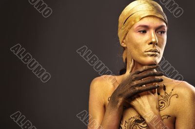 Portrait of young sexy woman in golden paint 